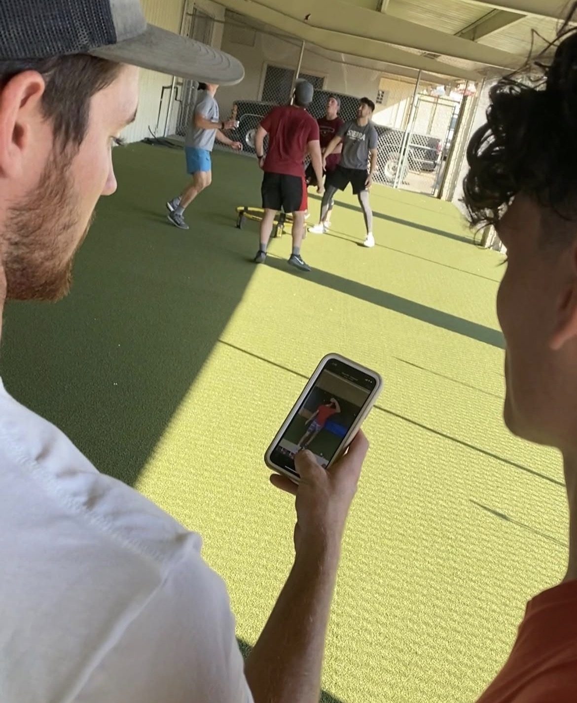 Tommy Sleva reviewing pitch video with an athlete